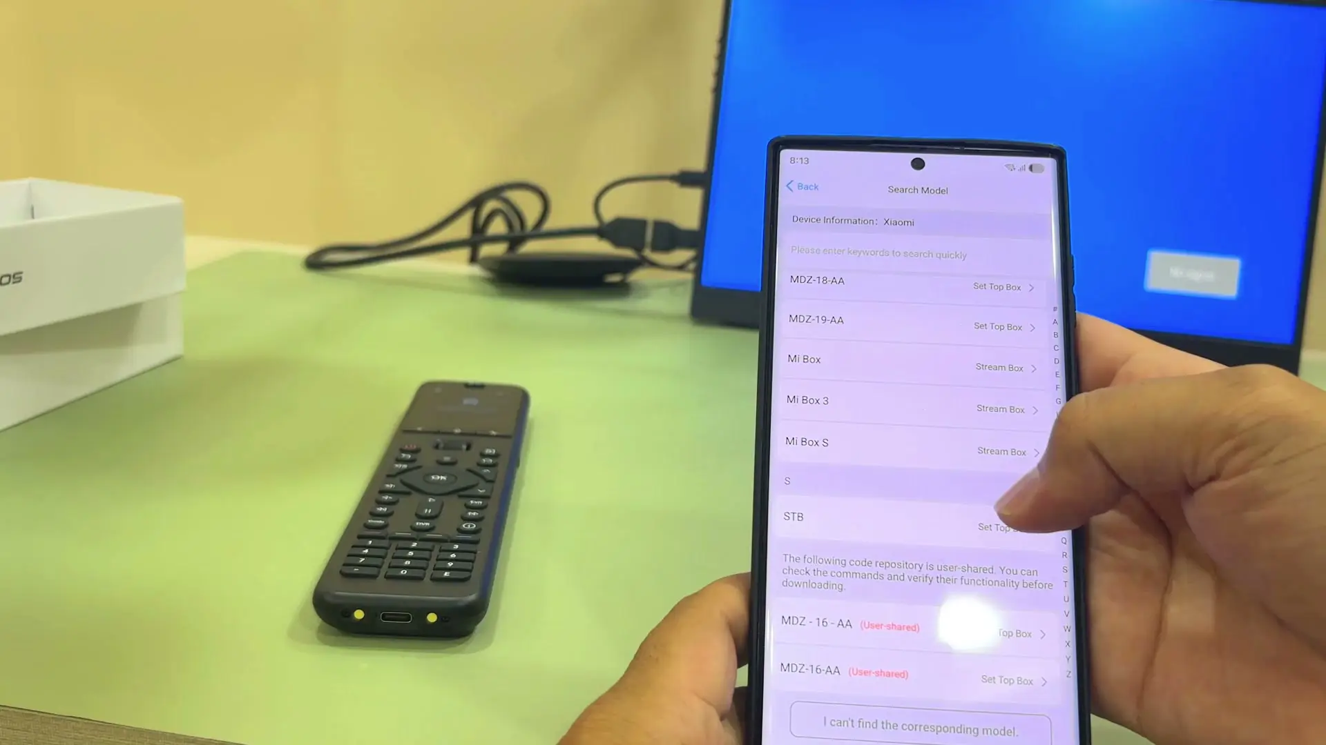A phone showing the SofaBaton app's IR model search screen for a Xiaomi device, listing set-top-box and streaming box models to choose from