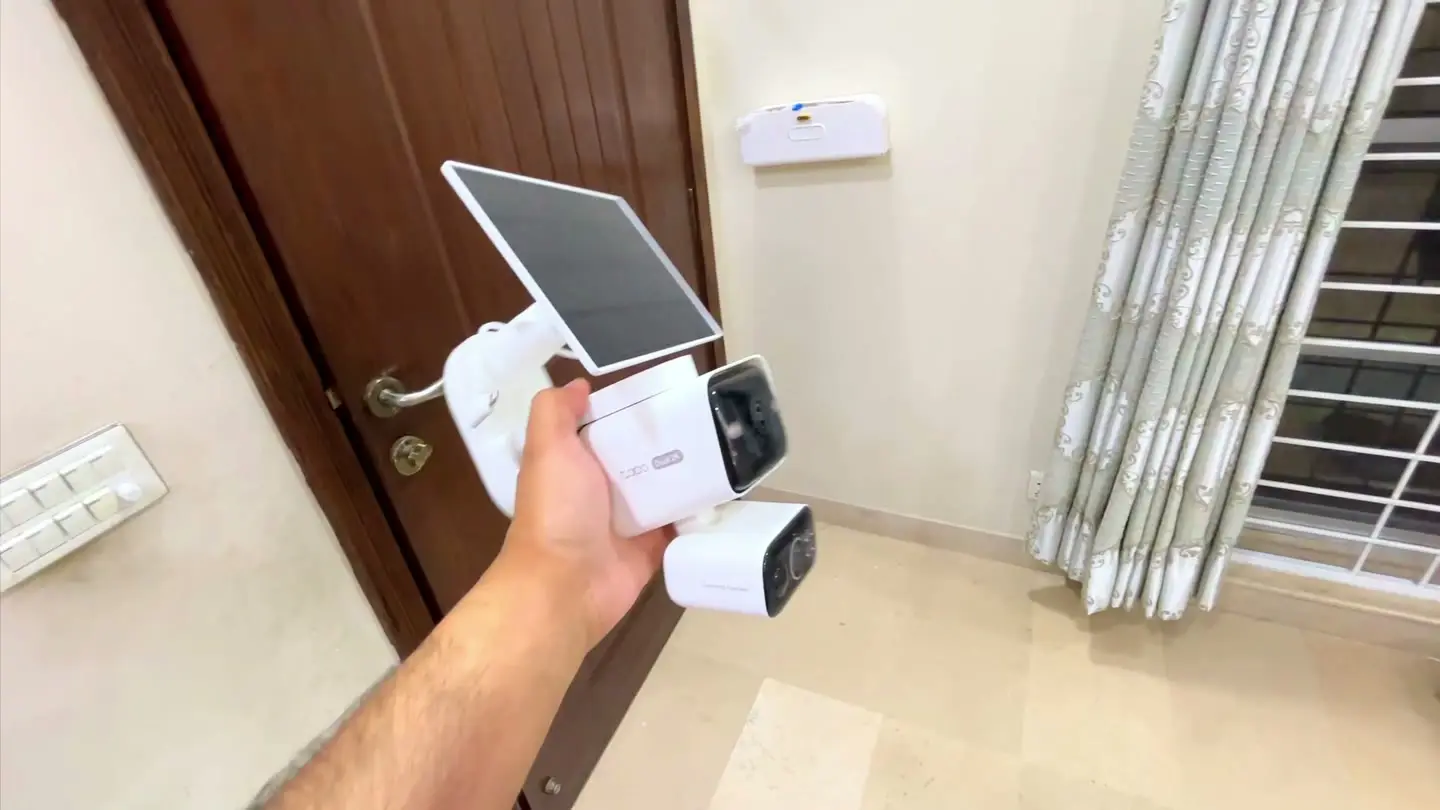 The solar panel and dual-lens C645D camera assembled as one wire-free unit held in hand