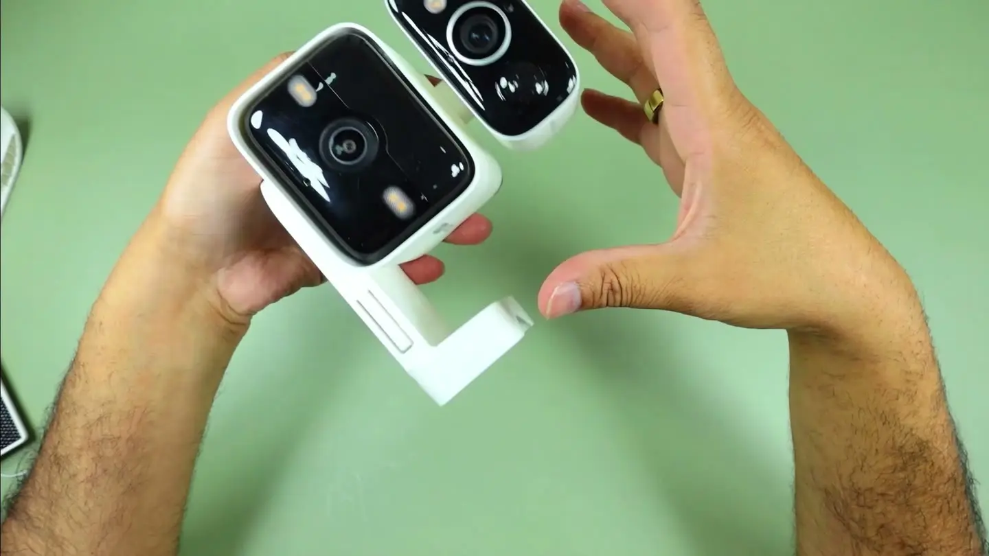 The dual-lens Tapo C645D camera held in hand during testing, showing its two stacked lens heads