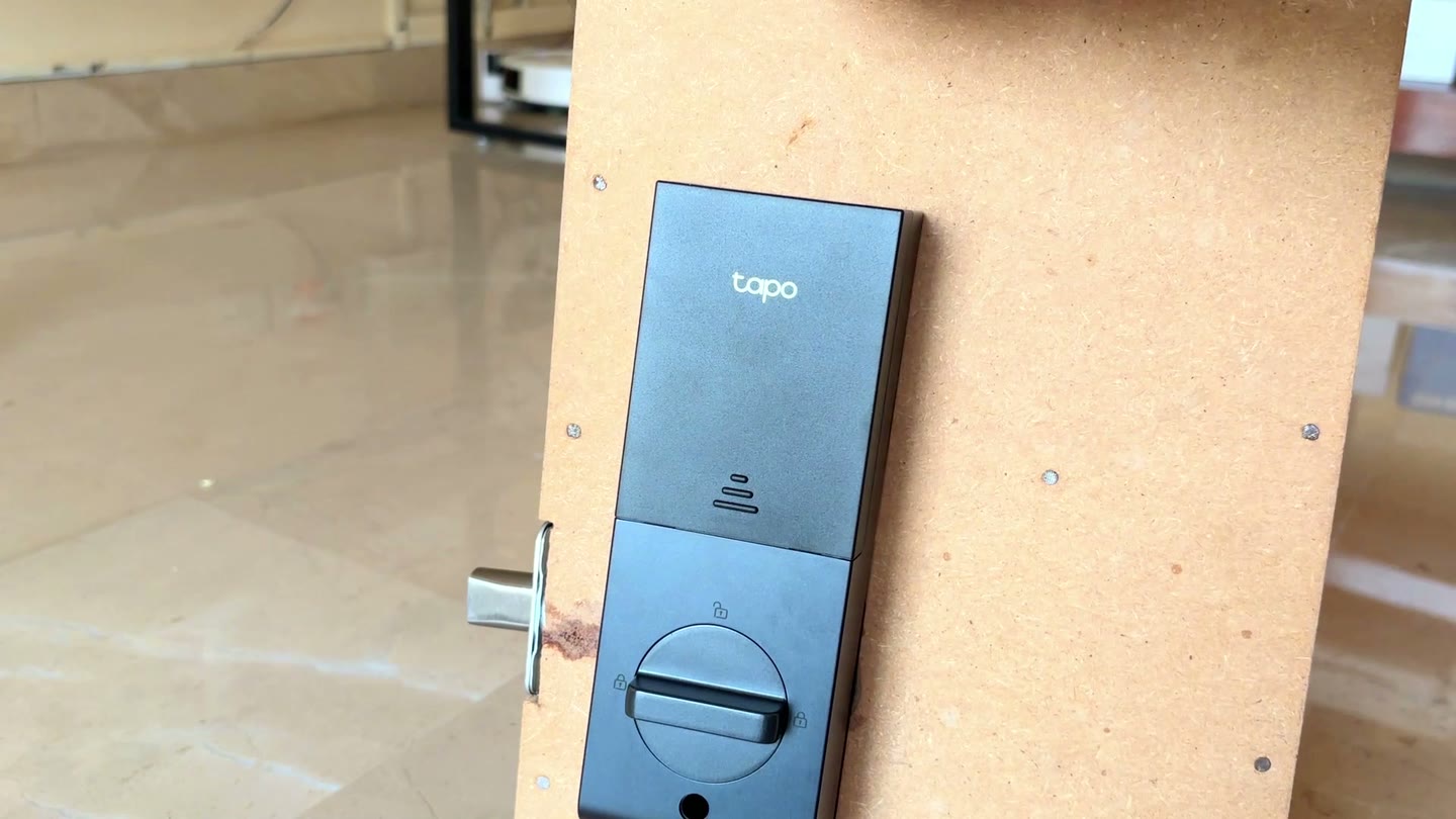 Tapo DL130 smart lock mounted on Tech With RR's lock test board, showing the Tapo branding on the front panel